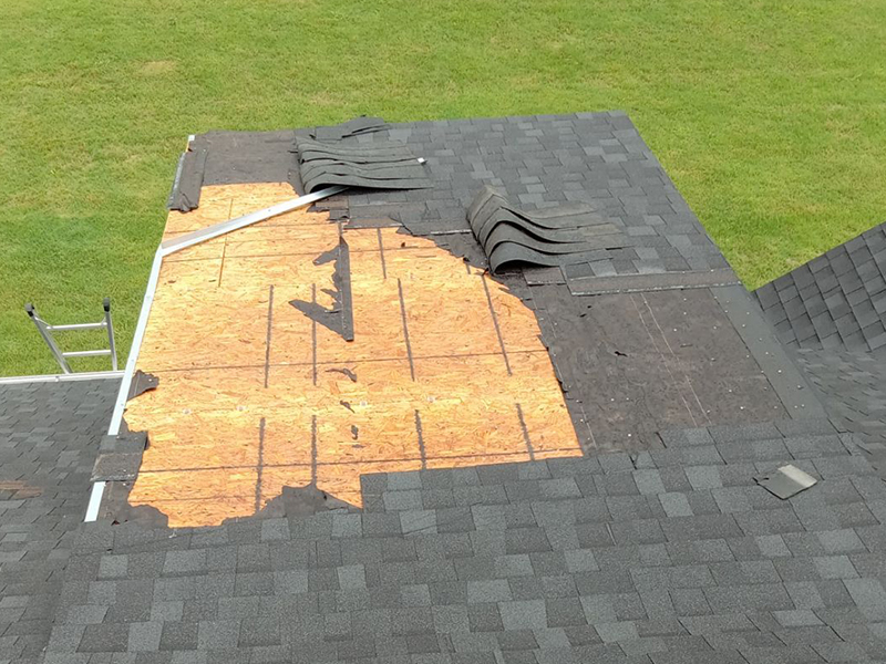 Damaged roof with missing shingles after a severe storm